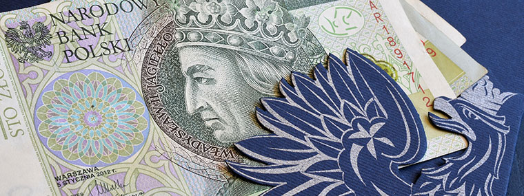 Banknoty stuzłotowe i ozdobnie wycięty wizerunek orła z godła RP